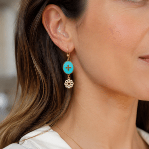 Boucles d’oreilles pendantes dorées Émail bleu motif floral portées par une femme