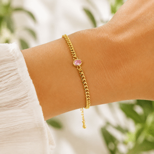Bracelet souple plaqué or pendentif goutte rose porté par une femme