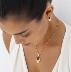 une femme portant la Parure main de Fatma avec pendentif et boucles d’oreilles bleues